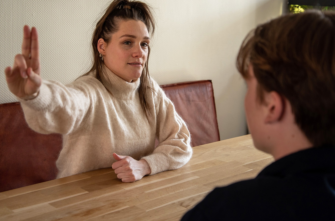 Behandelaar in gesprek met een jongere in de praktijk